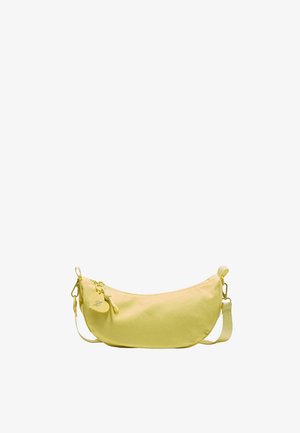 Sac d'épaule jaune en forme de croissant avec fermeture éclair, sangle réglable et une étiquette ronde en forme de cœur attachée près de la fermeture éclair.