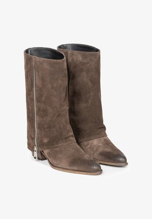 Brązowe zamszowe botki za kostkę o wysokim fasonie. Posiadają srebrny zamek po boku, spiczasty czubek i gładkie skórzane wnętrze. Niski, krojony obcas.