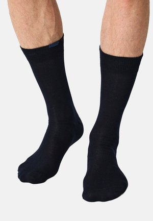 Marineblå bomuldsankelsokker med ribbede kanter, glat tekstur og sømløst tådesign, velegnede til både afslappet og formelt brug.