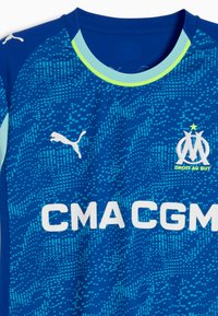 Mėlyna sportinė marškinė su tekstūriniais raštais, Puma logotipu ir Marseilio emblema. Balti "CMA CGM" užrašai per priekį.