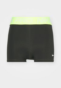 Sorte atletikshorts med en grøn og hvid Nike Pro linning, der har et tætsiddende design og en glat tekstur. Logo på nederste venstre side.