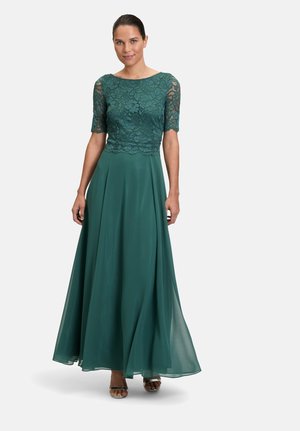 Teal evening dress with lace bodice and short sleeves, flowing chiffon skirt, and ankle-length hem. Paired with silver strappy sandals.