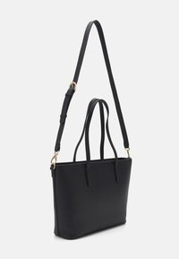 Black tote bag made of textured material, featuring two short handles and a long adjustable strap, with gold hardware accents.