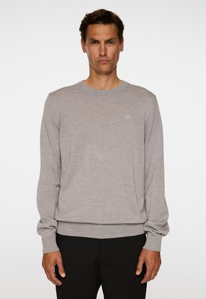 Hellgrauer Strickpullover mit langen Ärmeln und Rundhalsausschnitt, mit einem gerippten Saum und Bündchen. Dezentes Logo-Detail auf der Brust.