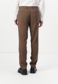 Pantaloni maro croiți cu un model subtil, țesătură de greutate medie, croi drept, două buzunare la spate și pantofi negri.