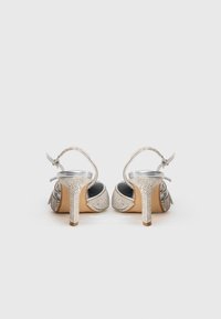 Sudraba augstpapēžu sandales ar dekoratīvām rhinestones, atvērtu aizmuguri, potītes siksniņu un strukturētu papēdi. Gluda iekšējā oderē. Klasisks dizains.