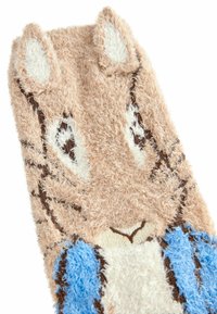 Vezelige beige stof met een cartoondieren gezicht, voorzien van witte oren, zwarte ogen en een blauw patroon op het lichaam. Zacht, pluche textuur in het geheel.
