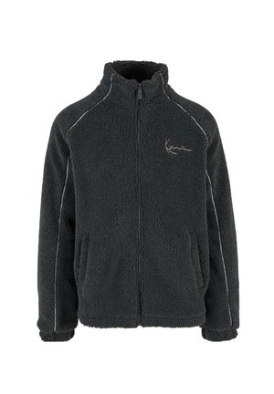 Black fleece jacket with zip closure, high collar, and two side pockets. Features light-colored trim along the seams. Soft, textured material.