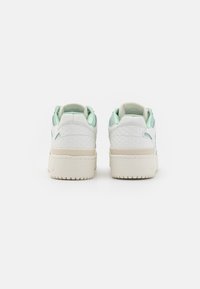 Vita sneakers med en texturerad läderövre, mintgröna detaljer, vadderad krage och en kraftig off-white gummisula.