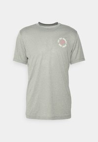 Světle šedé tričko s krátkým rukávem vyrobené z měkkého materiálu, s kulatým výstřihem a vytištěnou zprávou s usmívající se tváří na přední straně.