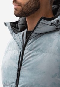 Himmelblauer Daunenjacke mit glänzender Textur, schwarzem Reißverschluss und Kapuze. Das Innere zeigt ein kontrastierendes dunkles Futter.