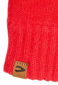 Rote gestrickte Mütze mit einem strukturierten Muster. Inklusive eines braunen Ledertags mit schwarzem Branding. Weiches, elastisches Material für zusätzlichen Komfort.