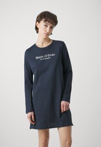 Abito a maniche lunghe blu navy in morbido cotone, con scollatura rotonda e testo bianco del logo centrato sul petto. Dettagli con fessure laterali.