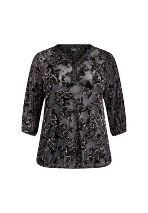 Melna blūze ar ziedu rakstu vara toņos. Tai ir apaļš kakla izgriezums, trīs ceturtdaļu piedurknes un brīva piegriezuma. Maiga, zīdaina tekstūra.