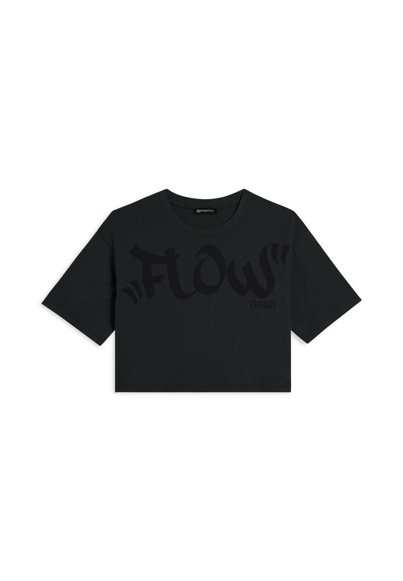 Camiseta negra corta hecha de algodón suave, con gran texto negro "Flow" y "Freddy" en el frente, y con mangas cortas anchas.
