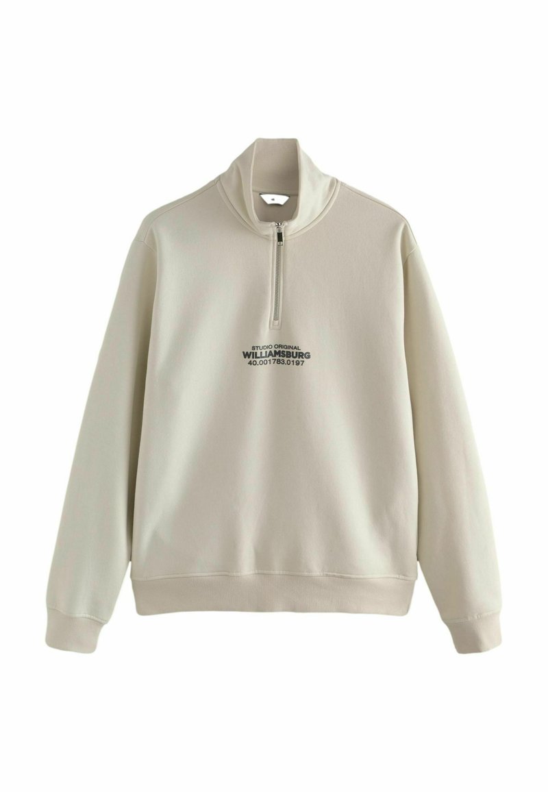 Beżowy sweatshirt z suwakiem na ćwierć, z wysokim kołnierzem, zdobiony grafiką z przodu w czarnym kolorze oraz miękką, gładką teksturą materiału.
