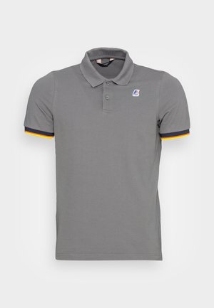 Szara koszulka polo z krótkim rękawem, dwoma guzikami, kołnierzykiem, małym wielokolorowym logo na piersi oraz granatowo-żółtą lamówką na krawędziach rękawów.