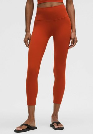 Hochtaillierte Leggings in Orange, aus dehnbarem Stoff. Weiche Textur, figurbetontes Design, knöchellang und ohne sichtbare Muster.