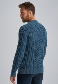 Männerpullover in Blau aus Strick mit strukturierten Mustern, ausgestattet mit einem gerippten Saum und Bündchen sowie einer Knopfdetail am hinteren Hals.
