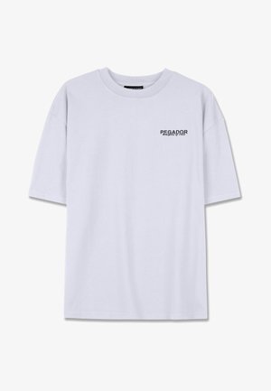 Bela bomba iz bombažnega materiala z okroglo izrezano ovratnikom in kratkimi rokavi. Na levi strani prsnega dela je majhen črn napis "PEGADOR".