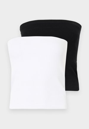 Haut noir sans manches associé à un pantalon noir taille haute avec une coupe droite. Les accessoires comprennent un petit sac noir et des chaussures pointues.