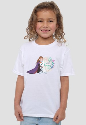 White cotton t-shirt featuring a colorful graphic of a girl in a purple cape hugging a snowman, with the text "Warm hugs" and floral accents.