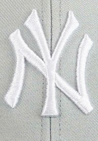 Graue Kappe mit einem erhabenen weißen gestickten "NY"-Logo. Das Design ist einfach mit klaren Linien und einer glatten Textur.