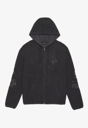 Juodas zip-up bliuzonas, pagamintas iš tekstūruoto poliesterio. Įrengtas gobtuvu, priekinėmis kišenėmis ir siuvinėtomis logotipų detalėmis ant rankovių. Minkštas ir šiltas išvaizda.