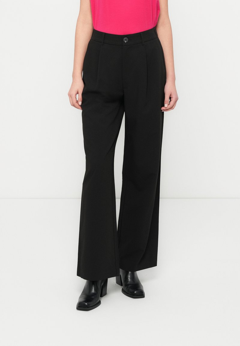 Μαύρο παντελόνι με φαρδιά μπατζάκια από απαλό ύφασμα, με κλείσιμο με κουμπί μπροστά και δύο πλαϊνές τσέπες. Συνδυασμένο με μαύρες μπότες με τετράγωνη φιάπα.