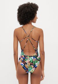 One-piece swimsuit with a colorful tropical print, featuring a low back design with cross-back straps. Made of smooth, stretchy fabric.