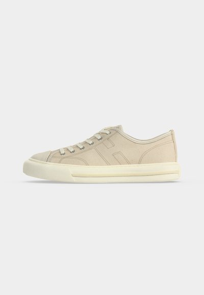 Beiger niedriger Leinensneaker mit Schnürung vorne und cremefarbener Gummisohle, von der linken Seite auf weißem Hintergrund dargestellt.