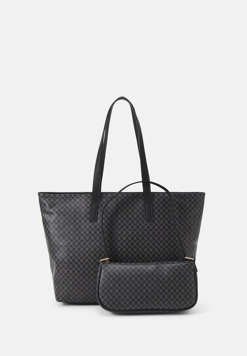Deux sacs à main noirs à motifs, un grand cabas avec de longues anses et un plus petit sac bandoulière, présentés sur un fond clair uni.