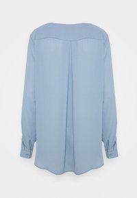 Blouse manches longues bleu clair avec un col arrondi, un détail plissé au dos et des poignets boutonnés. Tissu doux et lisse avec une silhouette fluide.