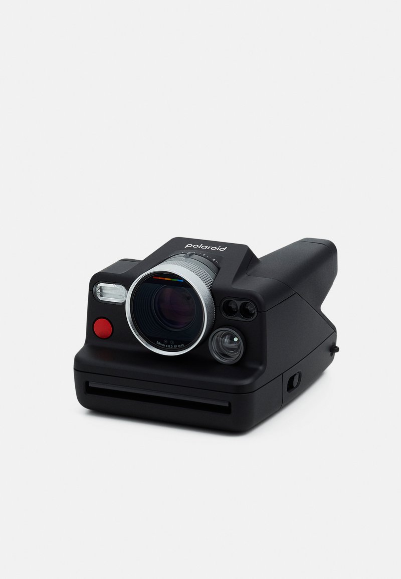 Polaroid camera with a matte black body, silver lens trim, front red button, and multiple viewfinder lenses. Includes a film slot at the base.