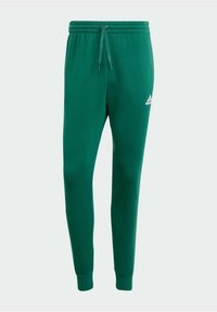 Green sweatpants made of soft material, featuring an elastic waistband with a drawstring and tapered legs. Includes a small white logo on the side.