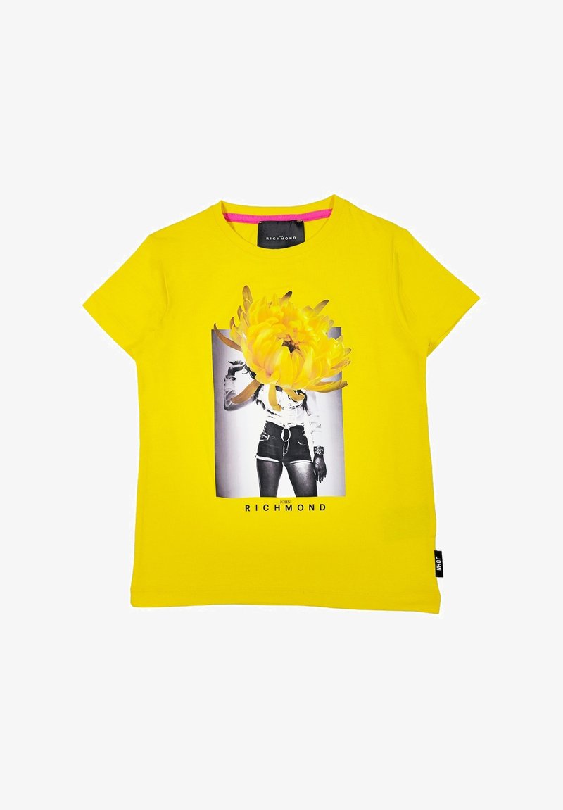 T-shirt di cotone giallo con stampa grafica di un fiore e pantaloni shorts in bianco e nero. Collo tondo e maniche corte.