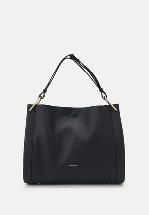 Schwarze Lederschultertasche mit dünnem verstellbarem Trageriemen, goldfarbenen Beschlägen und kleinem goldenem Markenlogo vorne in der Mitte.