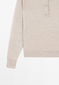 Jasnobeżowy sweter z dzianiny z długimi rękawami, listwą na guziki i prążkowanymi mankietami. Gładka faktura i swobodny fason z prostym brzegiem.