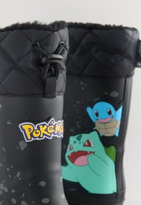 Schwarze gesteppte Regenstiefel mit Pokémon-Logo und den Charakteren Bisasam und Schiggy mit Kordelverschluss oben.