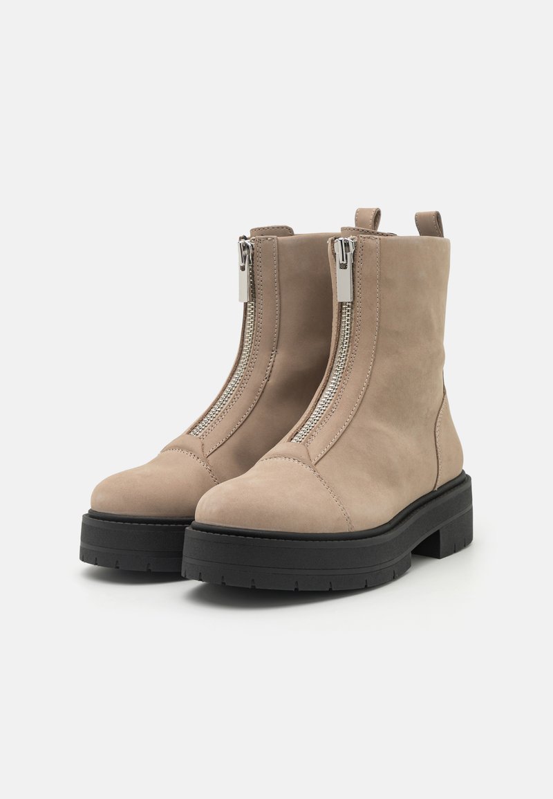 Beige Wildleder-Ankle Boots mit doppelten silbernen Reißverschlüssen, runder Spitze und dickem schwarzen Gummisohle. Verfügt über seitliche Schlaufen für einfaches Anziehen.