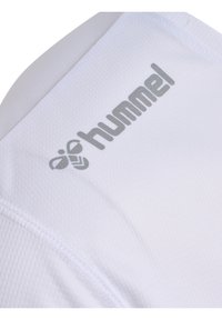 Weißes Sporttrikot mit strukturiertem Finish. Enthält das "hummel"-Logo in Silber auf der oberen linken Seite. Nahtdetails sind sichtbar.