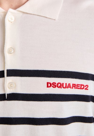 Valge polo särk horisontaalsete tumesiniste triippidega, kolme nööbiga kaeluse ja punase brodeeritud "DSQUARED2" logoga rinnal.