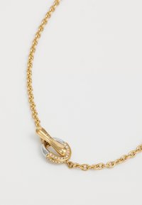 Gouden ketting met een zilveren en gouden sluiting versierd met kleine heldere edelstenen. De schakels zijn rond en in elkaar grijpbaar.