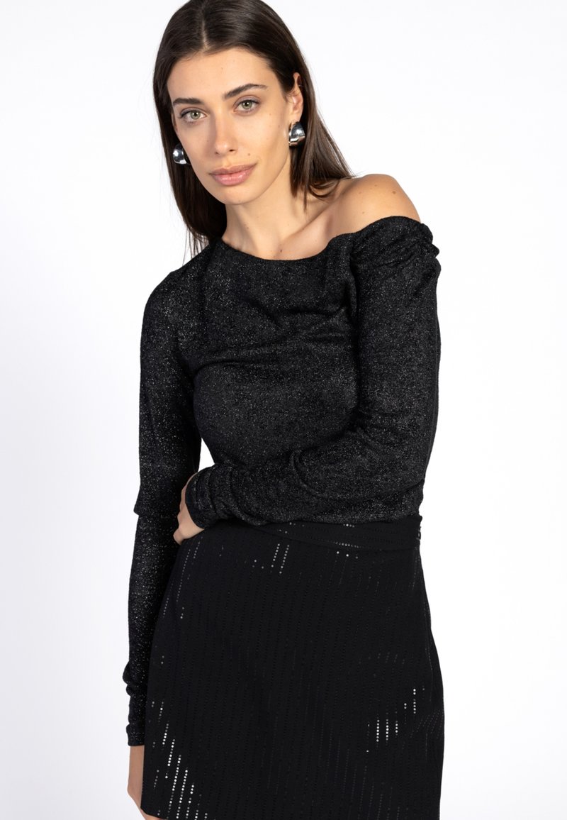 Zwarte off-the-shoulder top met lange mouwen, gemaakt van glanzende stretchstof. Heeft ruches langs de schouders en een zachte textuur.