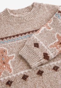 Pull en maille beige avec col et poignets côtelés, présentant des motifs géométriques et animaliers marron, orange et bleu sur la poitrine et la manche.