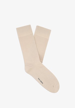 Para beżowych, żebrowanych skarpetek do połowy łydki z wzmocnionymi ściągaczami i napisem "PAOLO DENTE" na podeszwie.