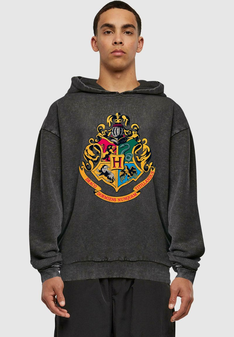 Sudadera de un gris oscuro hecha de tela suave, que presenta un gran diseño de escudo colorido con una "H" central y acentos dorados en la parte frontal.