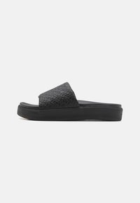 Sort slidesandal med en tekstureret overdel med et geometrisk mønster, en flad sål og et glat, fleksibelt materiale for komfort.