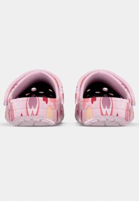 Ροζ κλογκς με λουλουδάτο μοτίβο που περιλαμβάνει καρδιές και σχέδια λουλουδιών. Επάνω μέρος με υφή και οπές αερισμού, με στιβαρή και ανθεκτική σόλα.