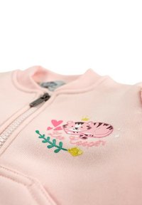 Sweat-shirt rose zippé avec un motif de tigre cartoon, agrémenté de cœurs et de feuilles. Confectionné en tissu doux à la texture lisse.